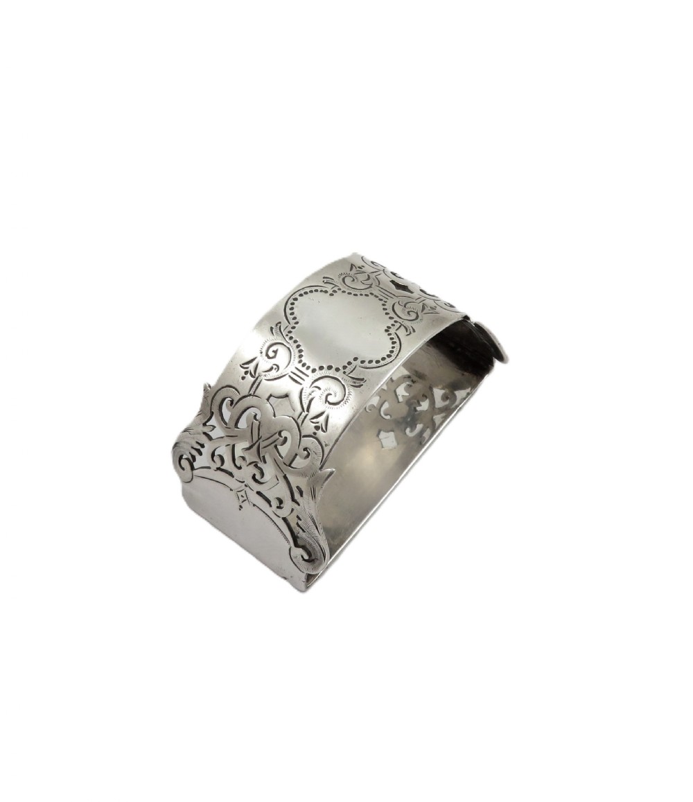 An engraved sterling silver napkin ring resting inside an open red leather presentation case lined with dark red velvet and cream silk. View IX