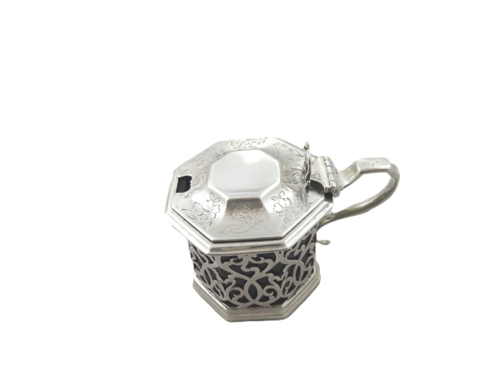An octagonal Victorian sterling silver mustard pot featuring pierced scrollwork and a cobalt blue glass liner. View VI