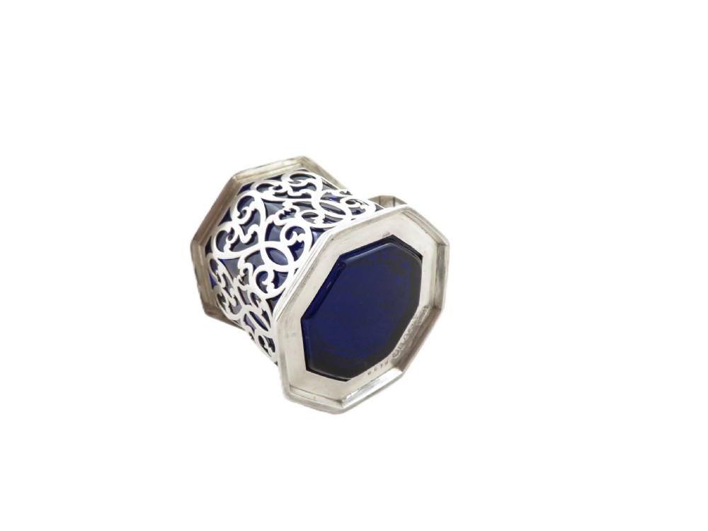 An octagonal Victorian sterling silver mustard pot featuring pierced scrollwork and a cobalt blue glass liner. View VII