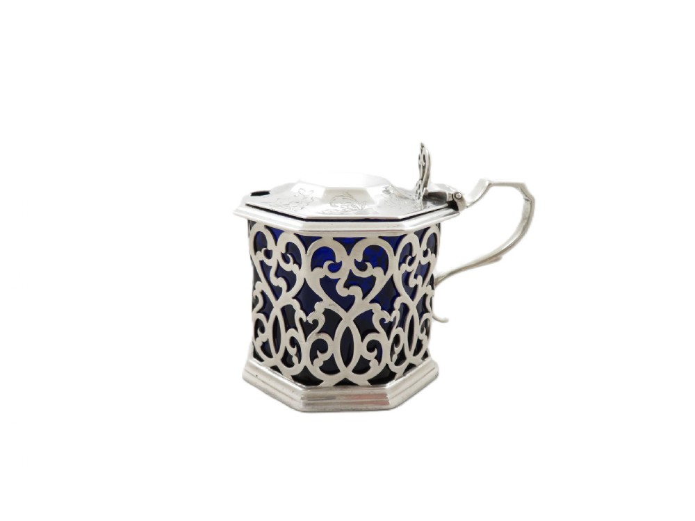 An octagonal Victorian sterling silver mustard pot featuring pierced scrollwork and a cobalt blue glass liner. View VIII
