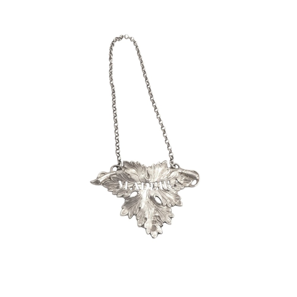 A Victorian sterling silver decanter label shaped as a vine leaf engraved with MADEIRA attached to a fine chain.