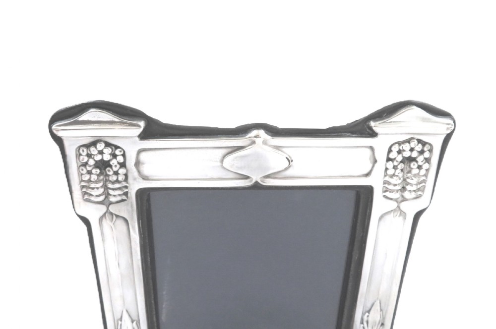 An antique sterling silver Art Nouveau picture frame featuring embossed botanical detailing and a dark easel backing. View III