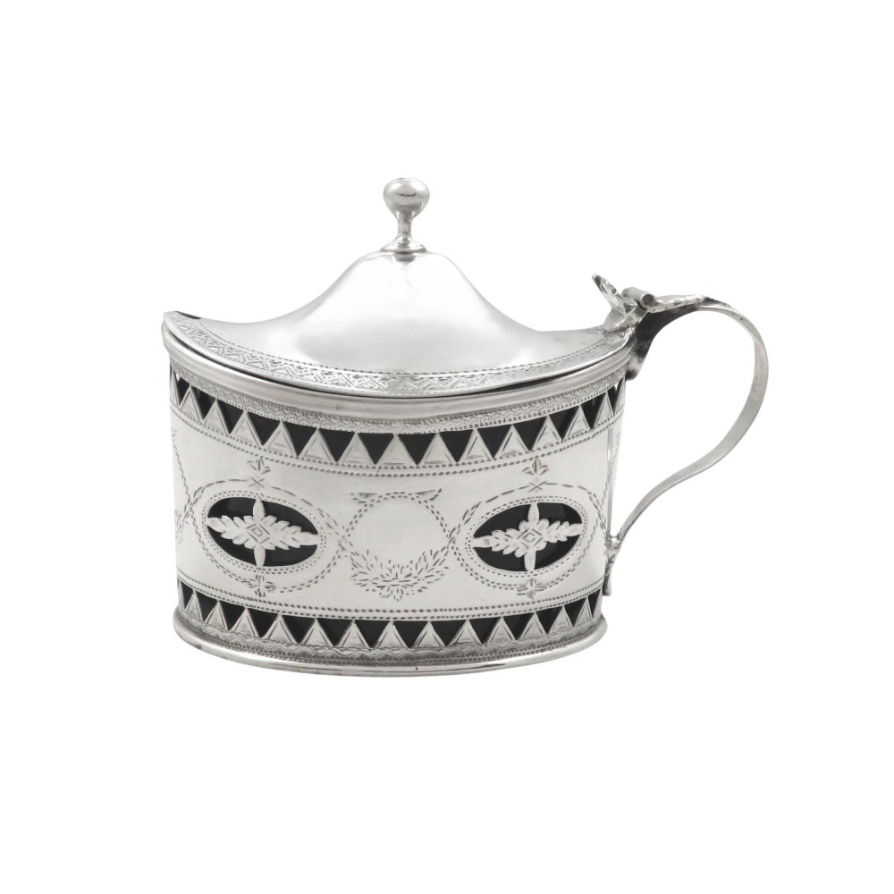 An antique Victorian sterling silver mustard pot featuring pierced geometric band decoration, engraved swags, a hinged lid, and a dark blue glass liner.