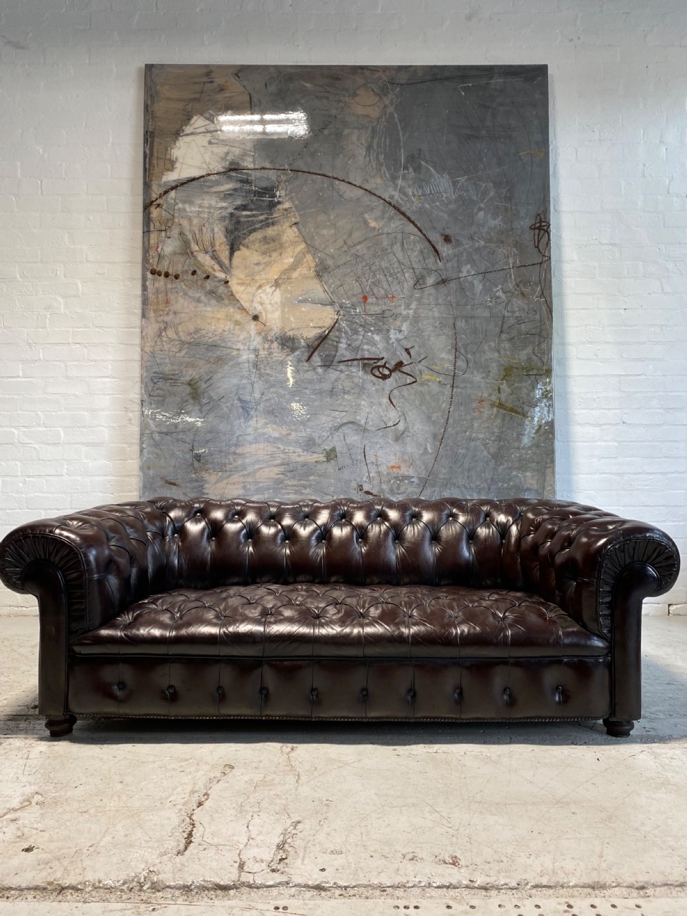 A nineteenth-century Chesterfield sofa upholstered in deep aubergine buttoned leather with rolled arms and turned wooden feet. View VIII