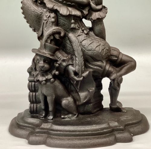 fig 1. A Victorian cast iron doorstop depicting the character Mr Punch seated next to Toby the dog on a stepped base.