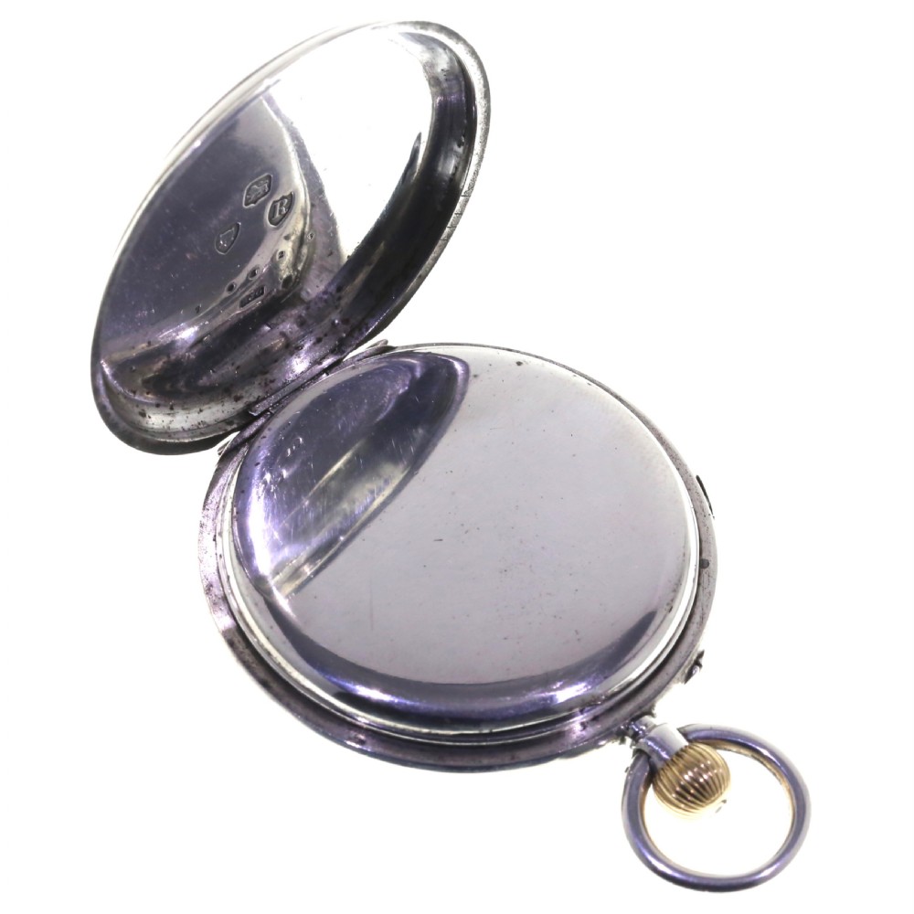 An antique silver open-face chronograph pocket watch featuring a white enamel dial with black Roman numerals and a brass winding crown. View III