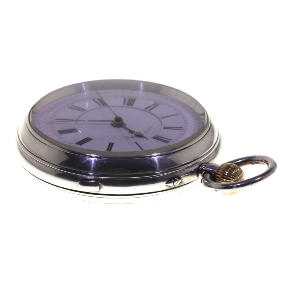 An antique silver open-face chronograph pocket watch featuring a white enamel dial with black Roman numerals and a brass winding crown. View VIII