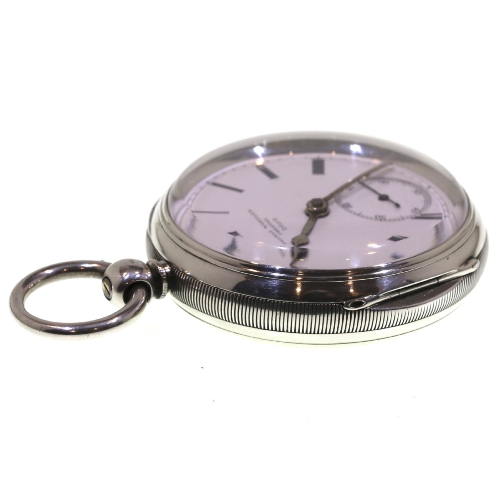 A Victorian silver pocket watch displaying a white enamel dial with black Roman numerals, dark steel hands, a subsidiary seconds dial, and an attached silver hanging loop. View XII