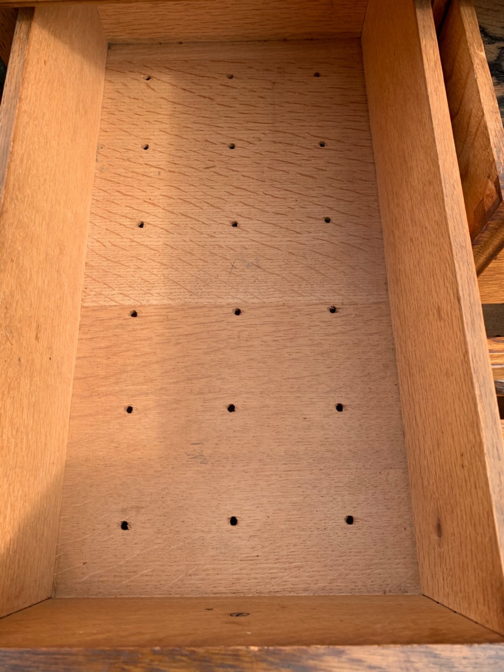A tall Victorian oak Wellington chest featuring twelve drawers arranged in two columns with carved wooden pulls set on a solid plinth base. View VI
