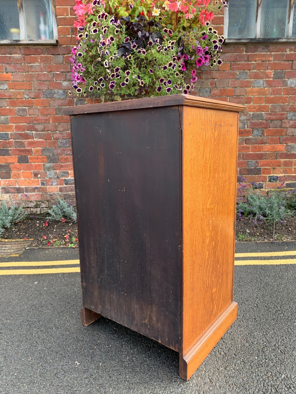 A tall Victorian oak Wellington chest featuring twelve drawers arranged in two columns with carved wooden pulls set on a solid plinth base. View VIII