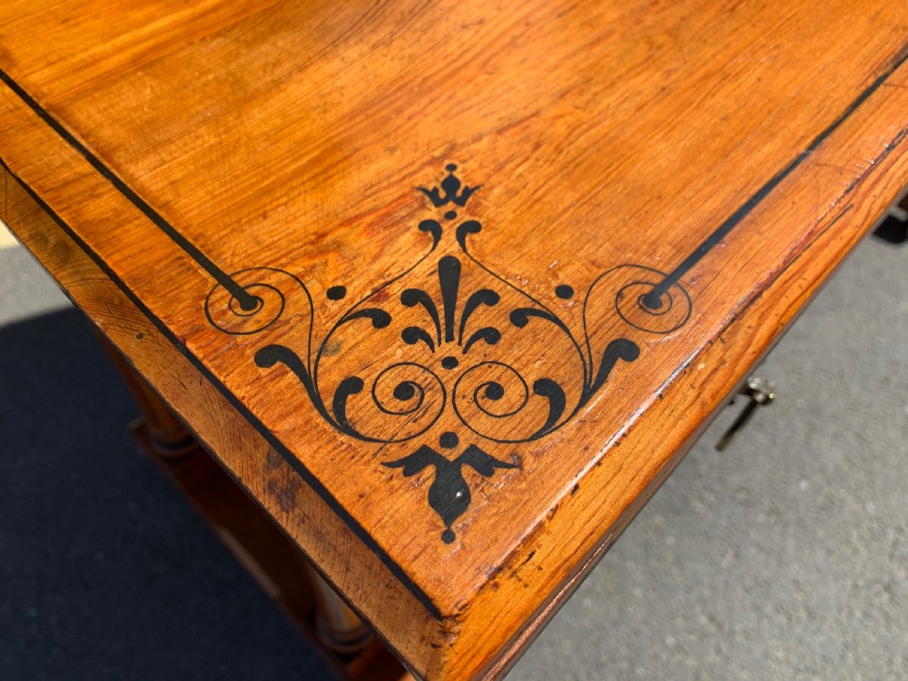 An Aesthetic Movement wooden dressing table featuring a central adjustable mirror, elevated trinket drawers, incised floral carvings, and turned legs on castors. View VII