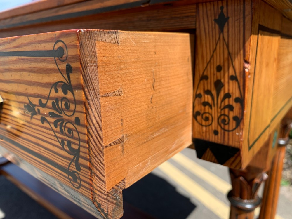 An Aesthetic Movement wooden dressing table featuring a central adjustable mirror, elevated trinket drawers, incised floral carvings, and turned legs on castors. View VIII