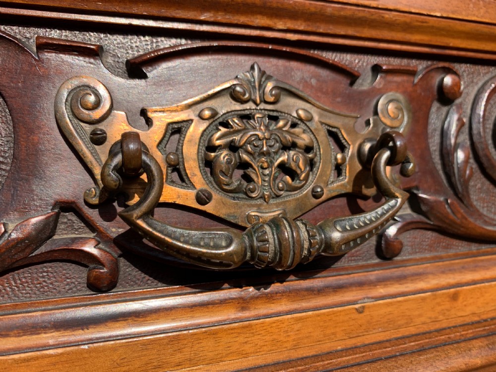 A tall Victorian mahogany bookcase with two upper glazed doors, two carved drawers, and lower carved cupboard doors. View III