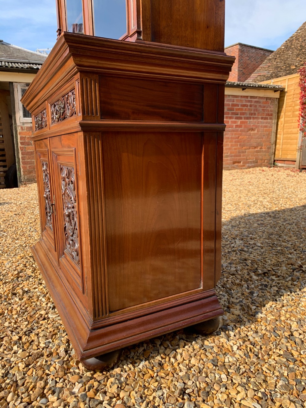 A tall Victorian mahogany bookcase with two upper glazed doors, two carved drawers, and lower carved cupboard doors. View VIII