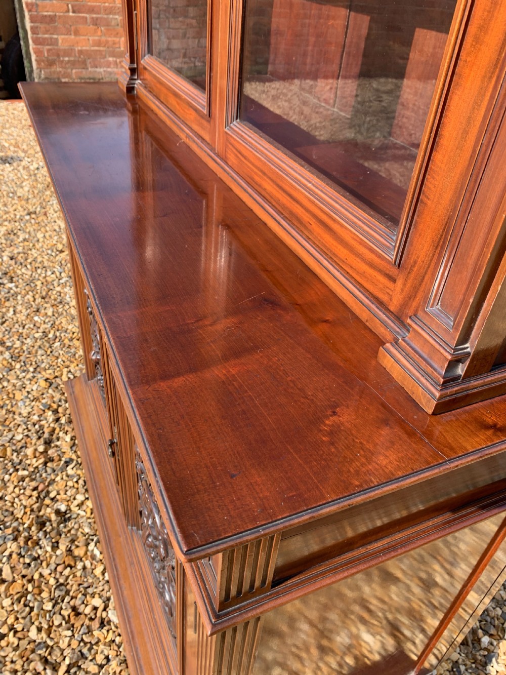 A tall Victorian mahogany bookcase with two upper glazed doors, two carved drawers, and lower carved cupboard doors. View IX