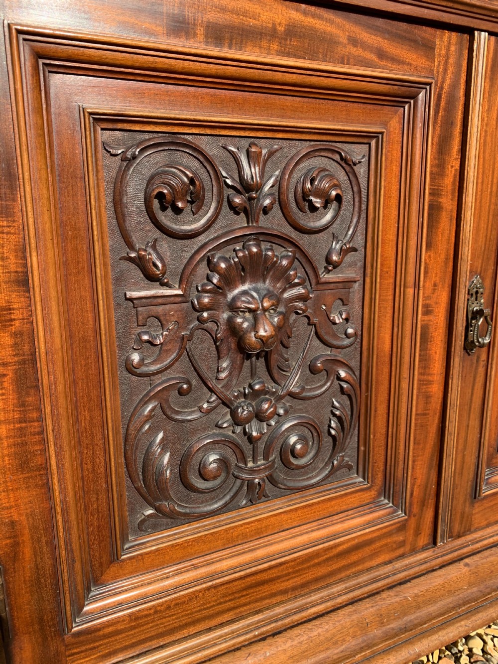 A tall Victorian mahogany bookcase with two upper glazed doors, two carved drawers, and lower carved cupboard doors. View XI