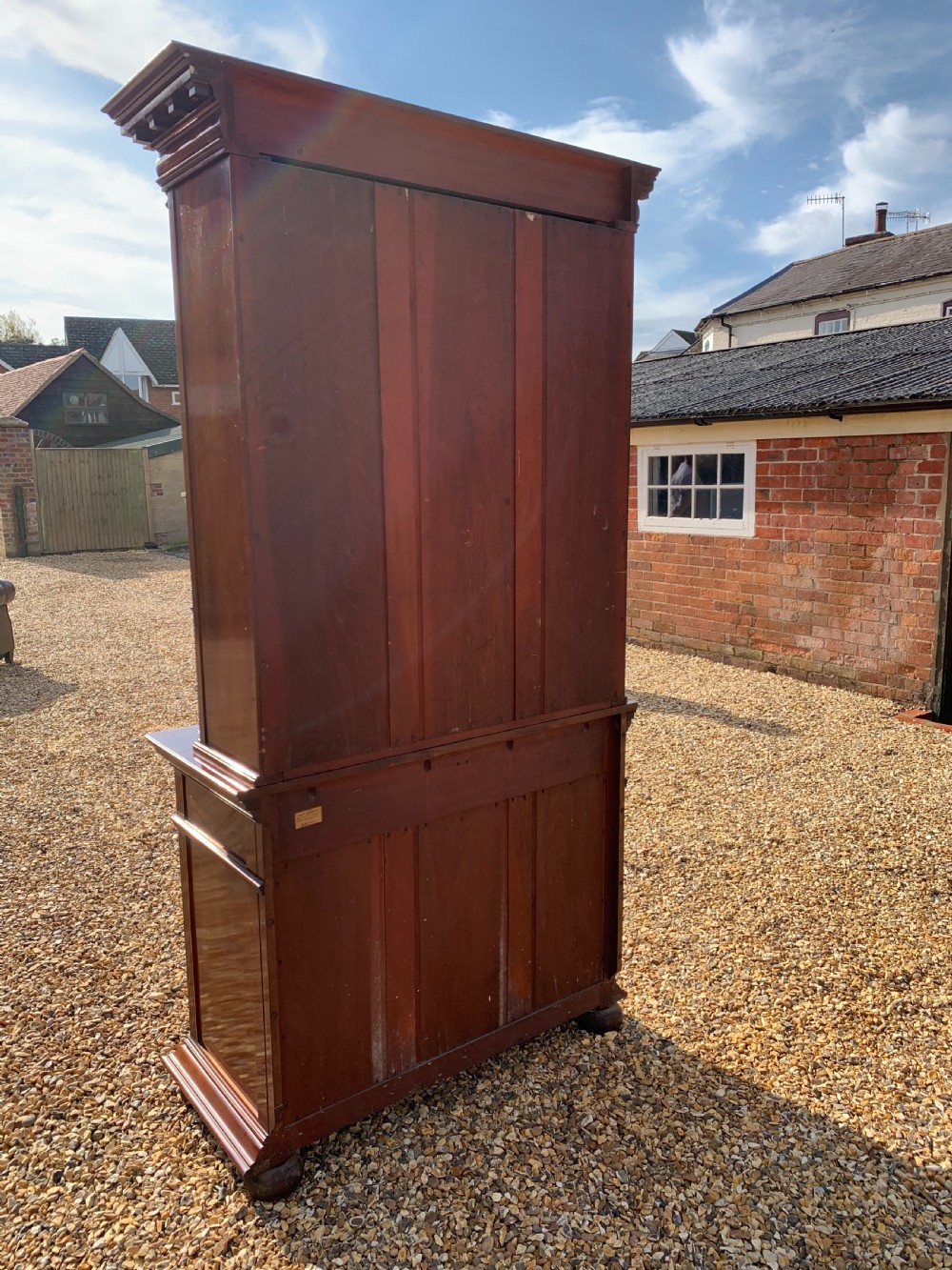 A tall Victorian mahogany bookcase with two upper glazed doors, two carved drawers, and lower carved cupboard doors. View XIII