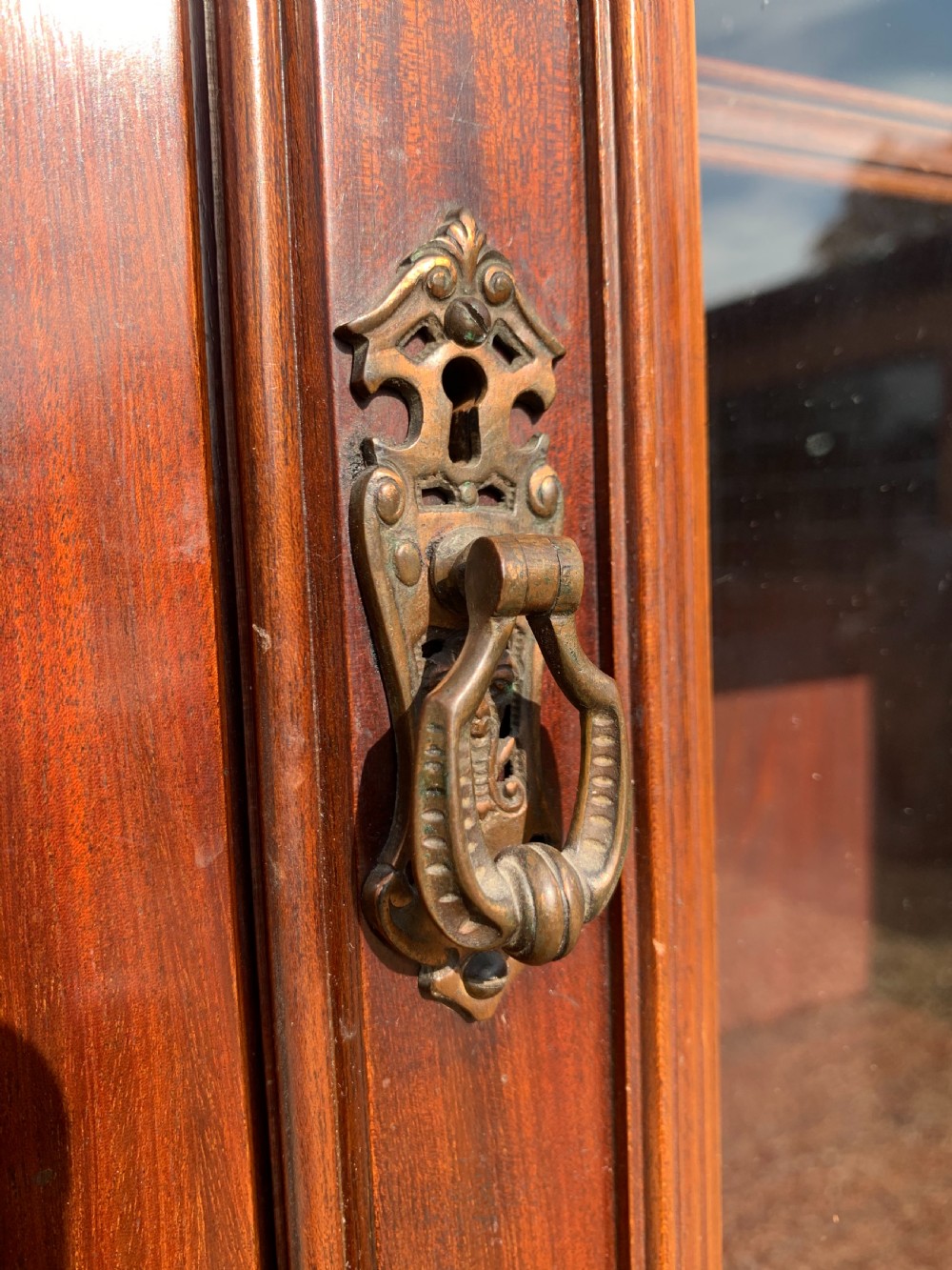 A tall Victorian mahogany bookcase with two upper glazed doors, two carved drawers, and lower carved cupboard doors. View XV