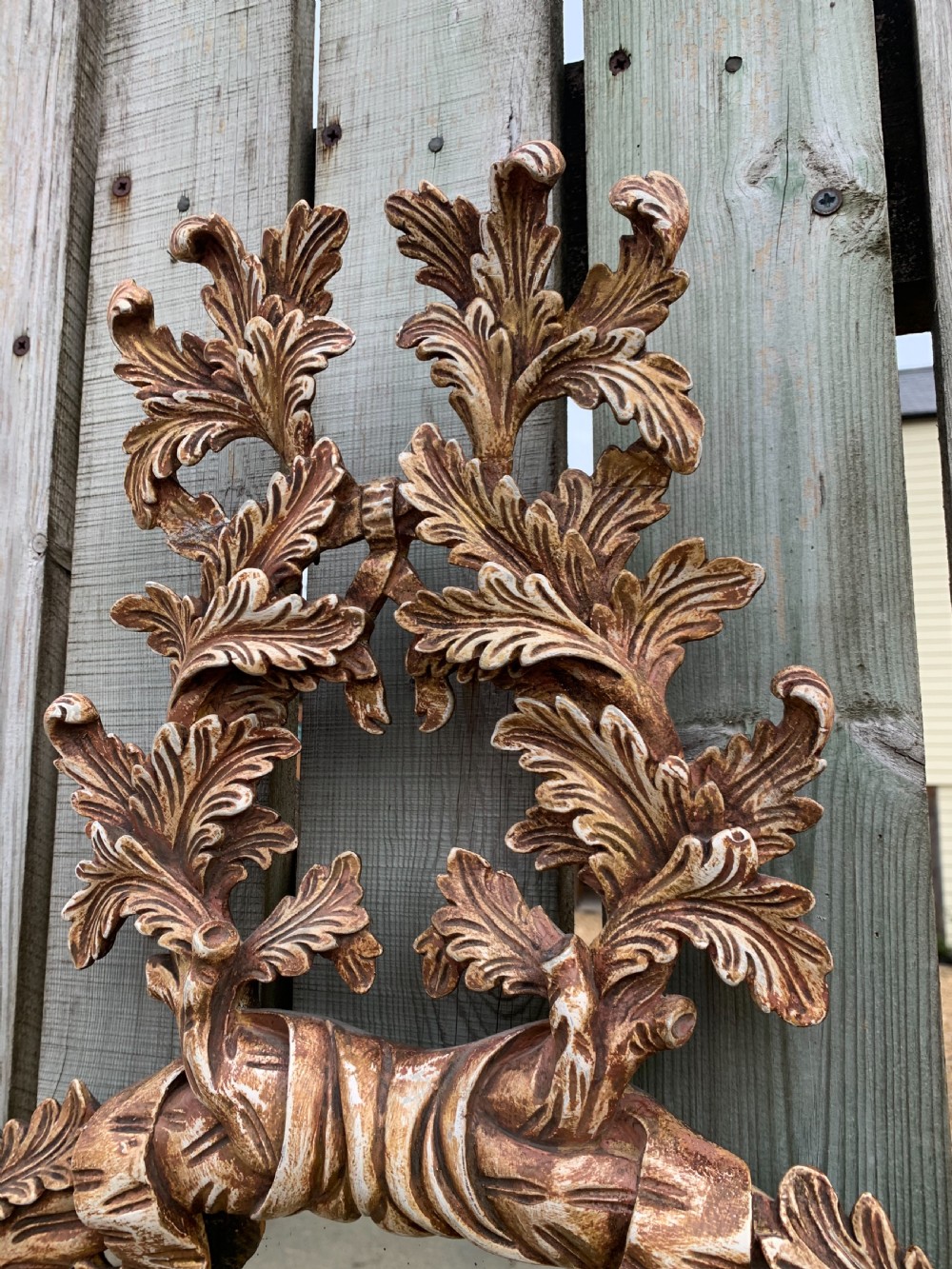 A pair of oval wall mirrors featuring ornate carved wooden frames with oak leaf motifs and ribbon crests in a painted finish. View II
