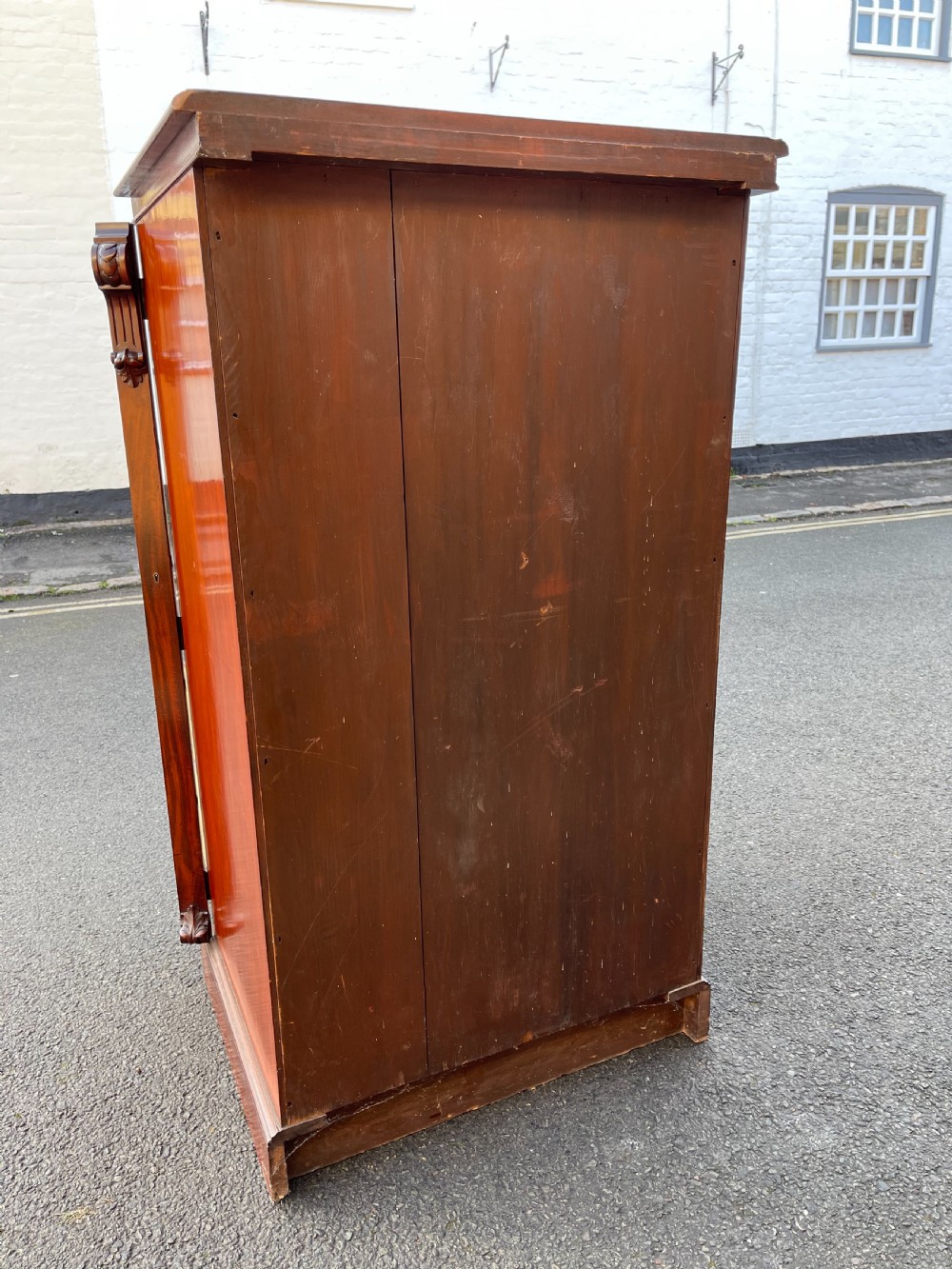 A tall Victorian mahogany Wellington chest featuring seven graduated drawers with turned wooden knobs, carved side corbels, and a side locking pilaster. View VII