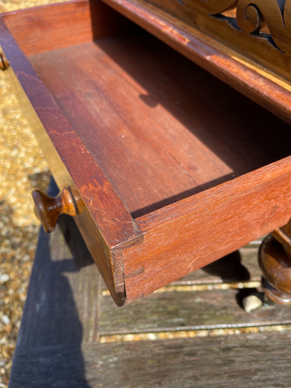 A Victorian figured walnut music Canterbury with pierced fretwork dividers, a single base drawer with turned wooden knobs, and turned legs on castors. View II