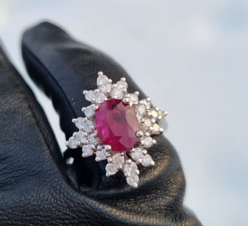 fig 1. An 18ct white gold cluster ring featuring a central cushion cut ruby surrounded by a starburst halo of diamonds.