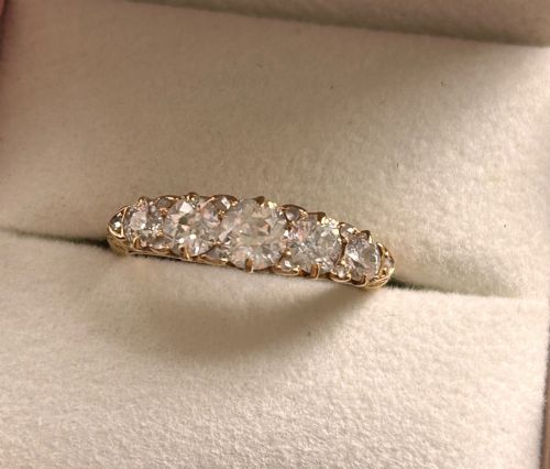 fig 1. An antique Victorian gold ring featuring five graduated diamonds set into an openwork scroll gallery.