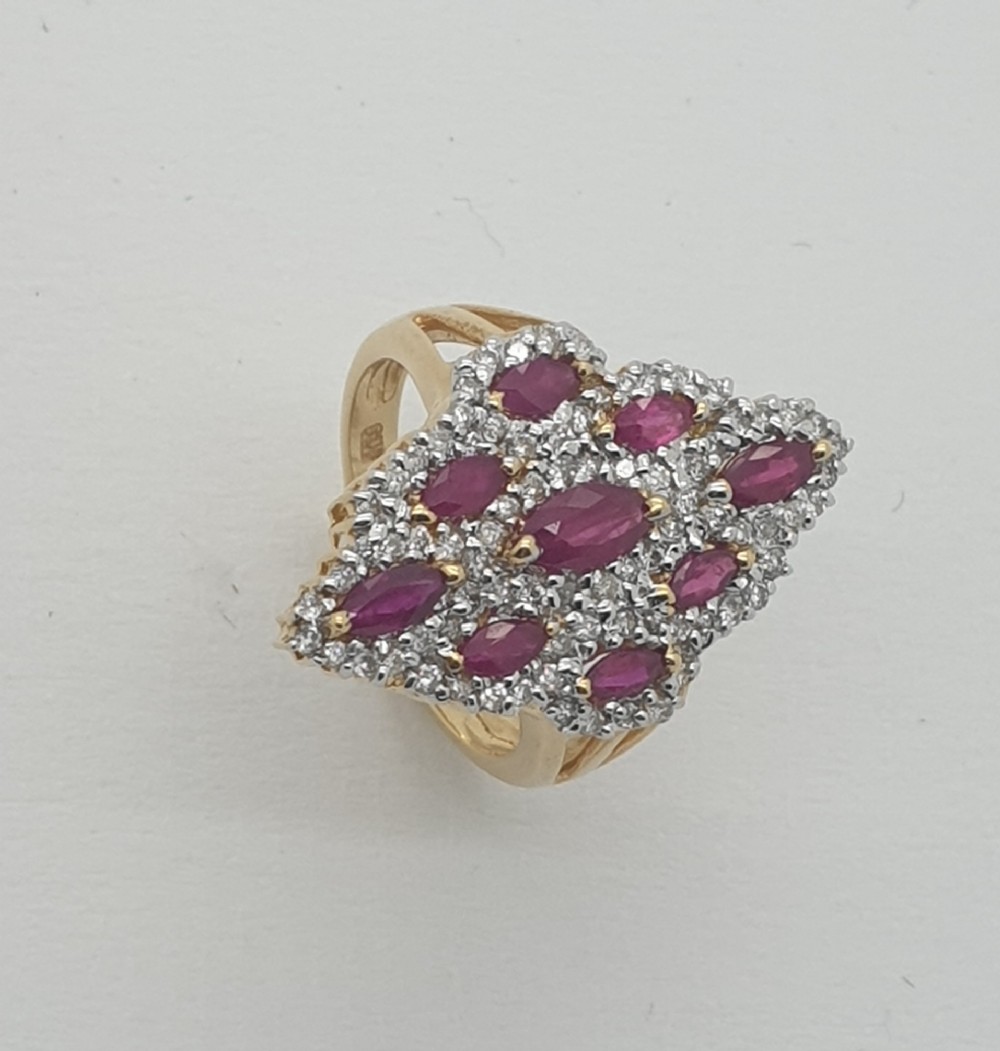 An 18ct yellow gold cluster ring set with marquise-cut red rubies surrounded by small pave-set diamonds.