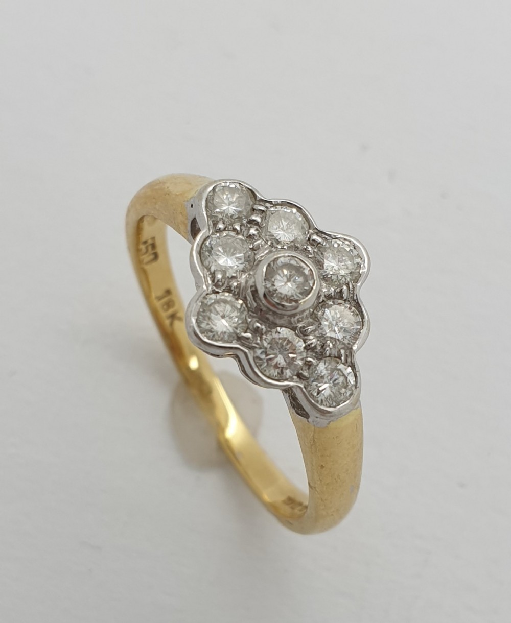 A 1950s yellow gold ring featuring a floral-shaped cluster head set with round diamonds in white metal.
