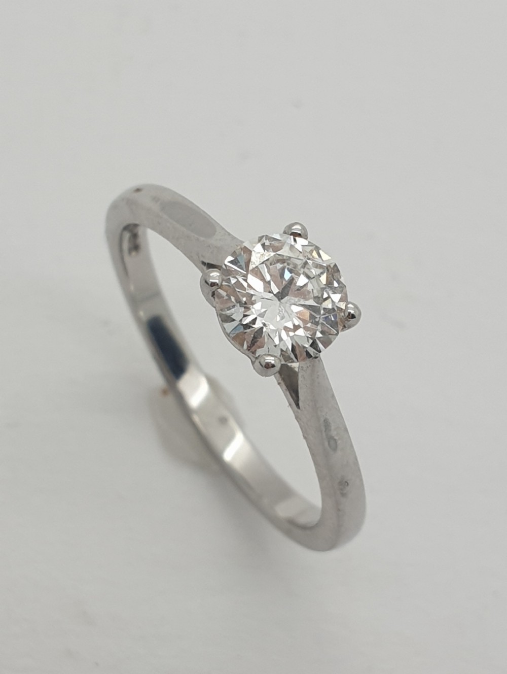 An 18ct white gold solitaire ring featuring a round brilliant cut diamond in a four-prong setting.