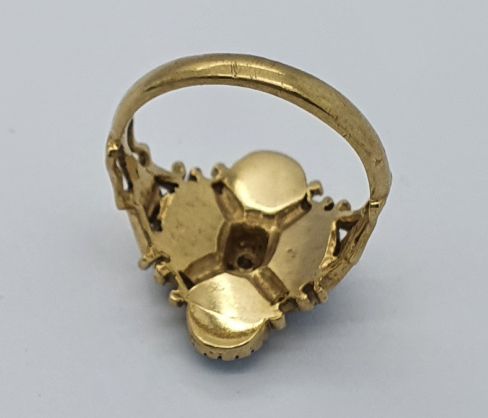 A 9ct yellow gold dress ring featuring four oval cabochon opals arranged in a cluster around a central brilliant-cut diamond, mounted on an ornate scrollwork band. View VI