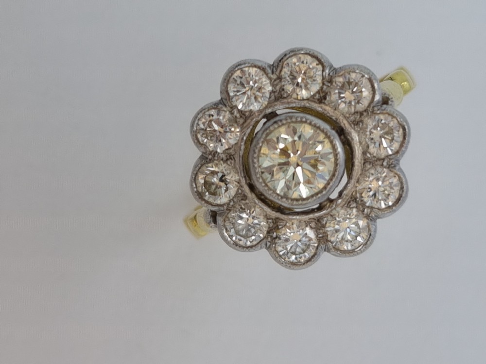 An antique diamond cluster ring featuring a central round diamond encircled by ten smaller diamonds set in a white metal head with a yellow gold band. View III