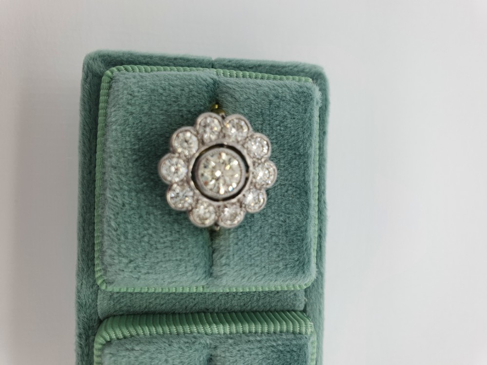 An antique diamond cluster ring featuring a central round diamond encircled by ten smaller diamonds set in a white metal head with a yellow gold band. View XII