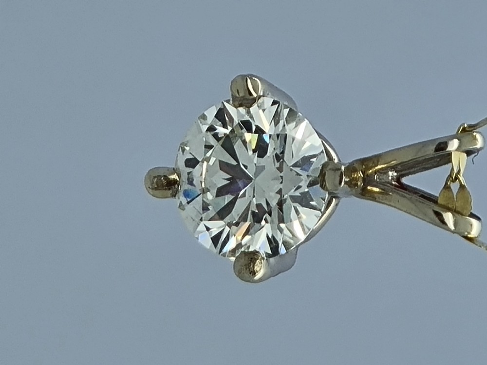 A round brilliant cut diamond set in a four-claw yellow gold pendant mount on a fine chain. View XIV