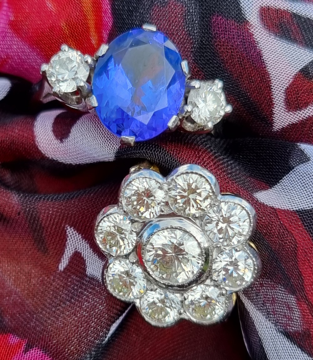 An 18ct yellow gold ring featuring a platinum-set floral head diamond cluster with a central round diamond encircled by eight surrounding diamonds. View X