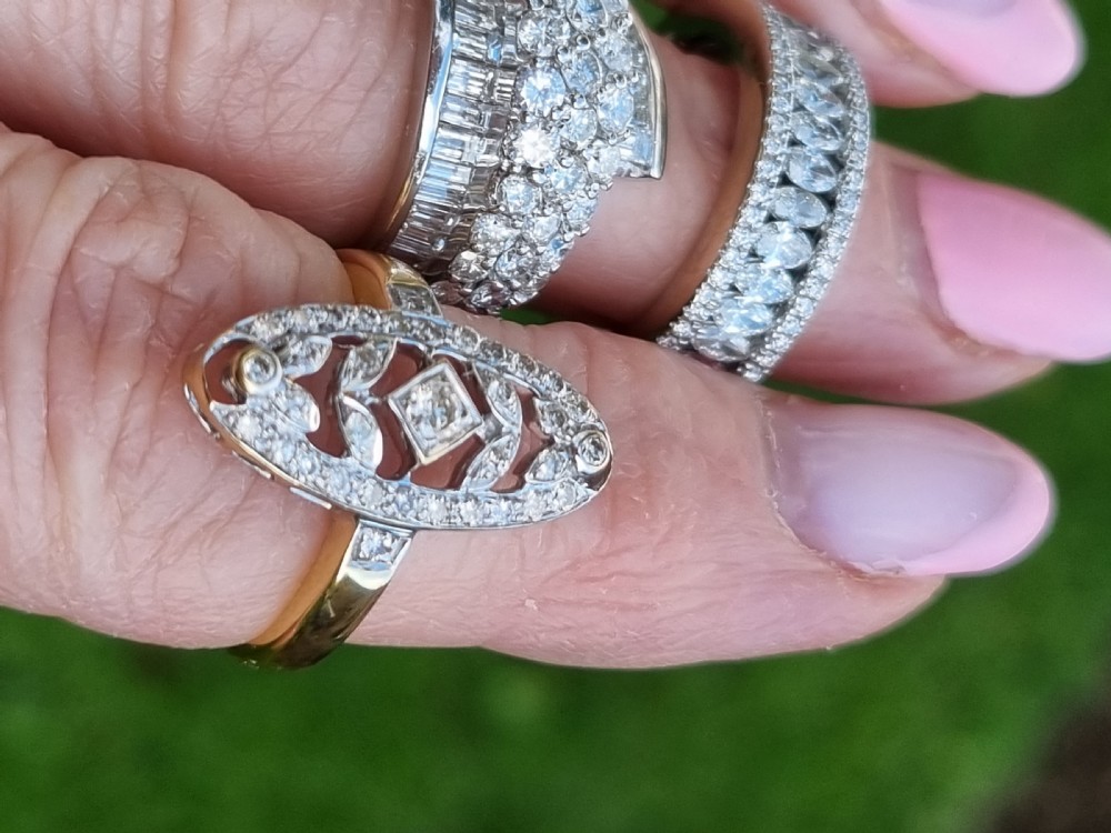 An antique yellow gold ring featuring an elongated oval pierced panel set with small diamonds and a central diamond motif. View III