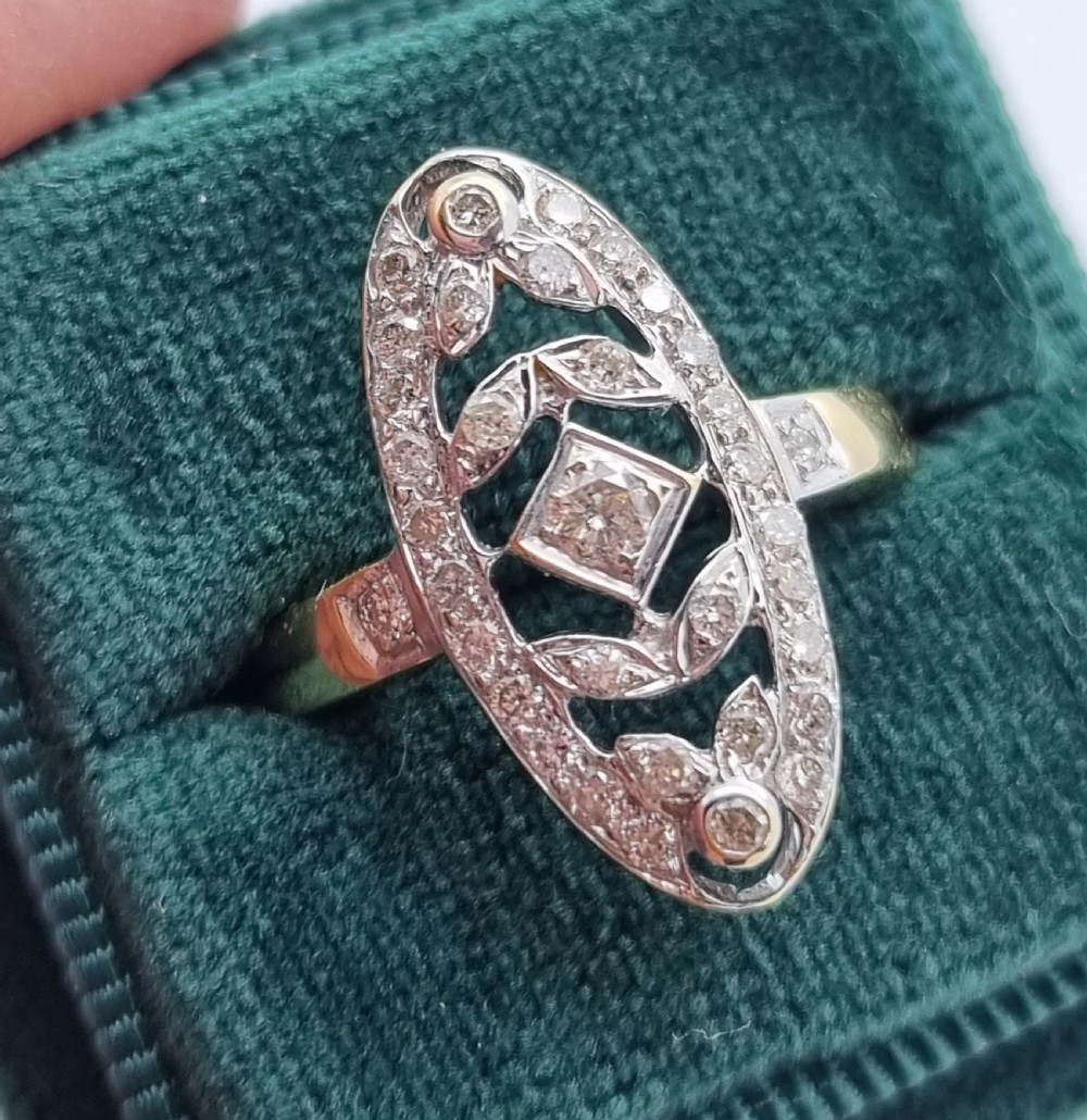 An antique yellow gold ring featuring an elongated oval pierced panel set with small diamonds and a central diamond motif. View VIII