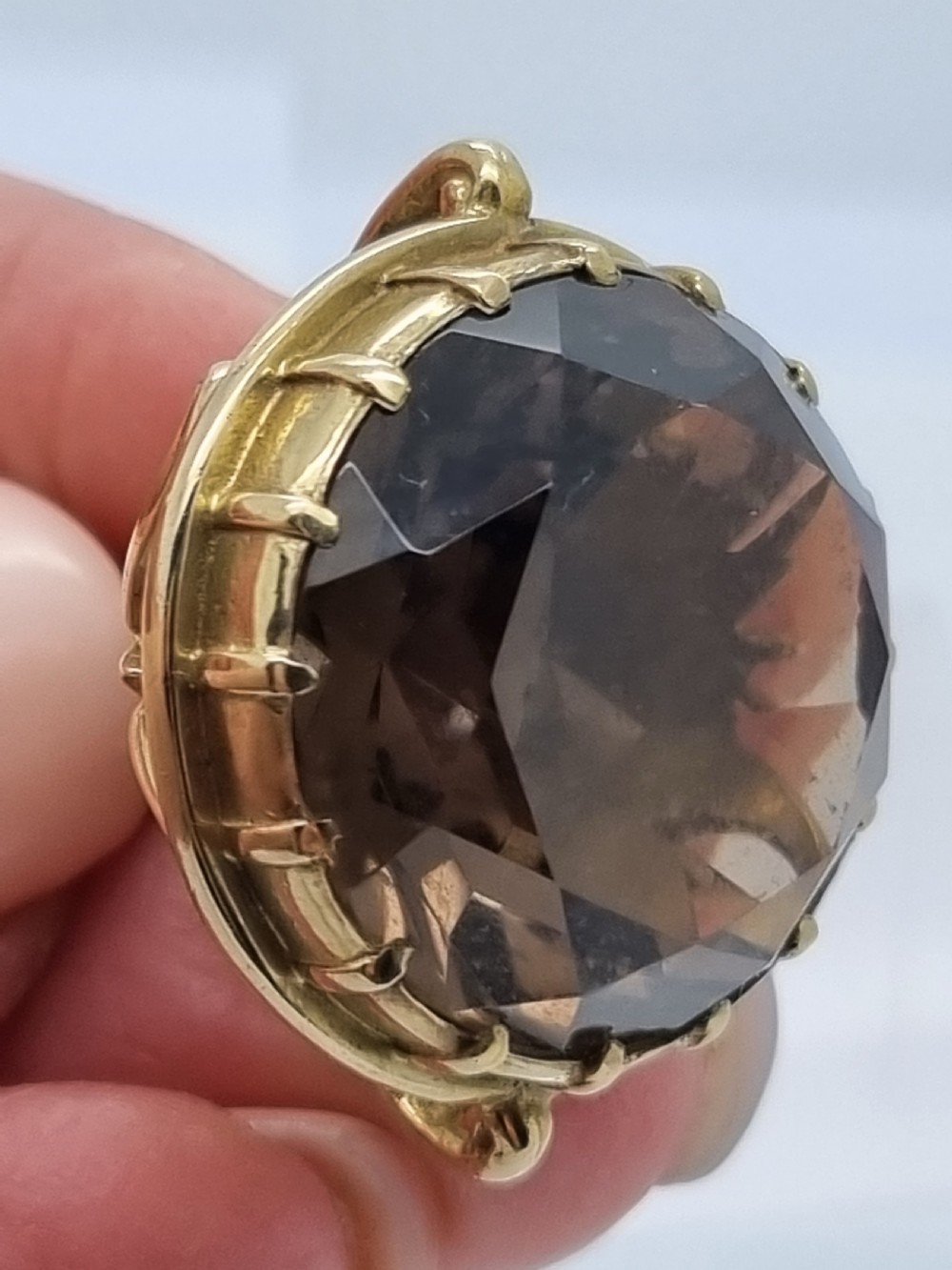 An ornate 9ct gold watch fob pendant set with a large faceted smokey quartz gemstone and detailed scrollwork frame. View VII