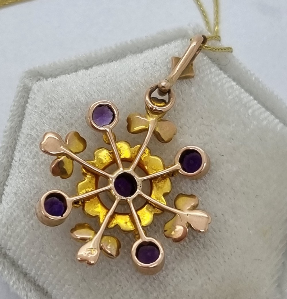 A Victorian gold starburst pendant set with round purple amethysts and delicate seed pearls hanging from a thin gold chain. View VII