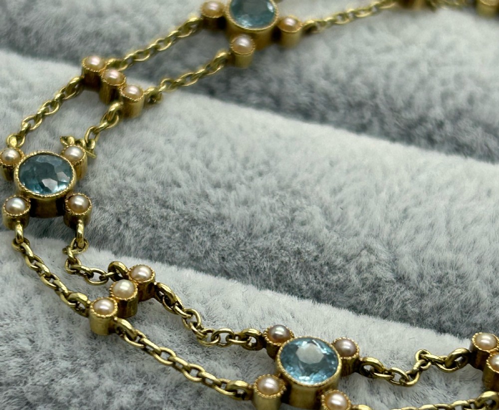 A late Victorian 15ct gold double trace chain bracelet set with round faceted aquamarines and split seed pearls. View V