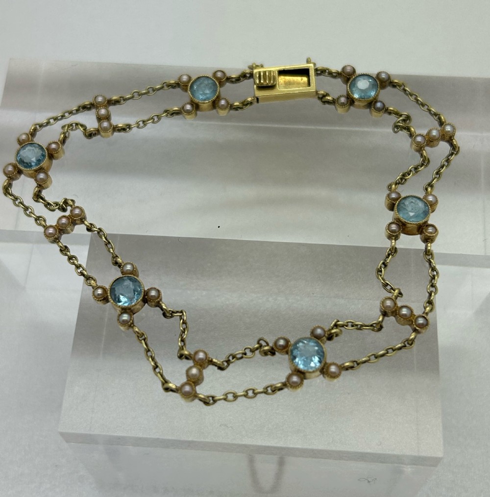 A late Victorian 15ct gold double trace chain bracelet set with round faceted aquamarines and split seed pearls. View VII