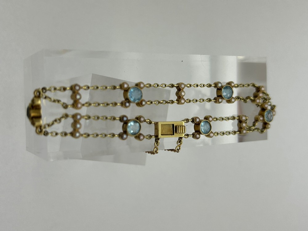 A late Victorian 15ct gold double trace chain bracelet set with round faceted aquamarines and split seed pearls. View IX