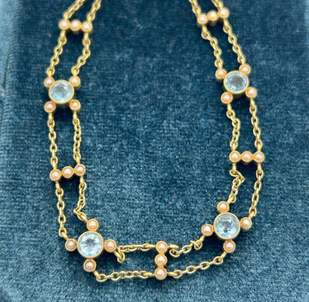 A late Victorian 15ct gold double trace chain bracelet set with round faceted aquamarines and split seed pearls. View X