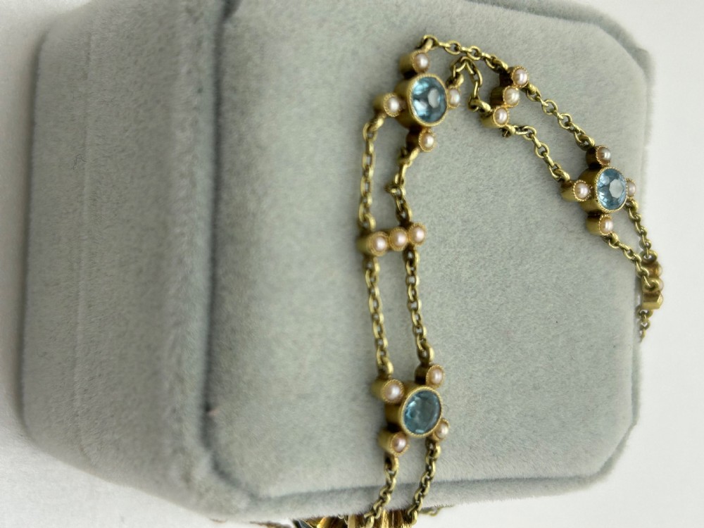 A late Victorian 15ct gold double trace chain bracelet set with round faceted aquamarines and split seed pearls. View XIV