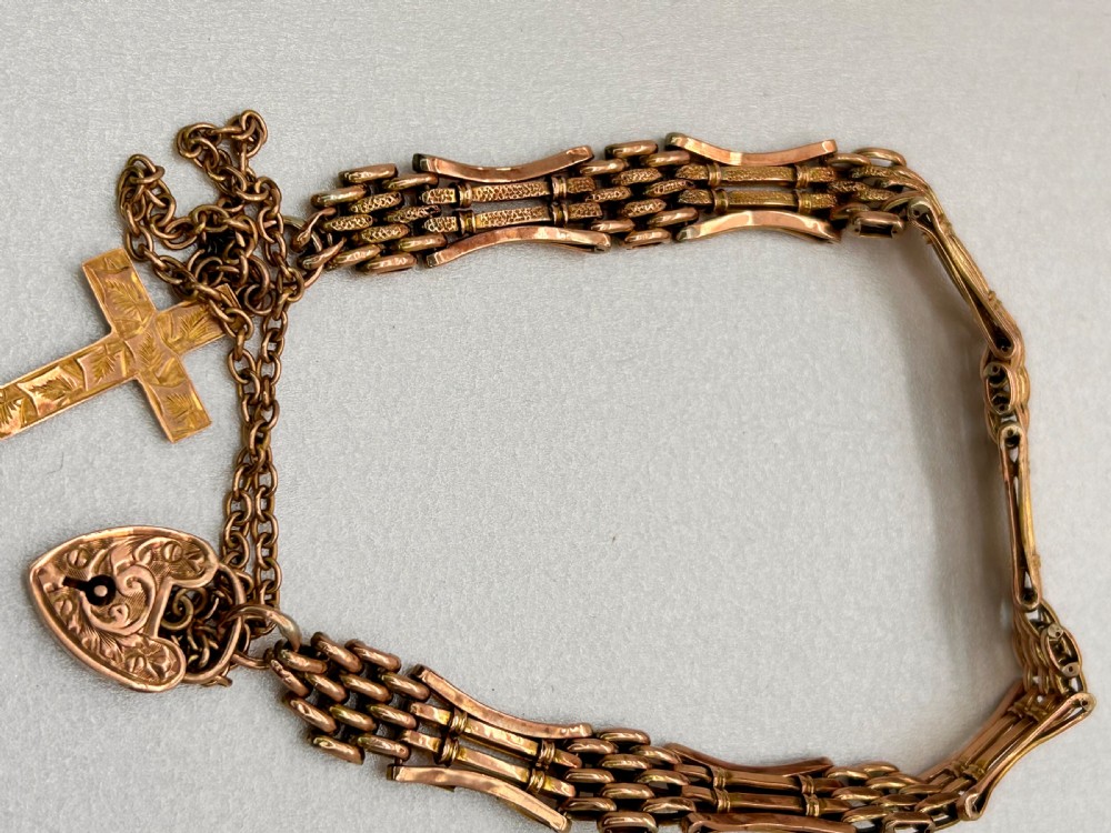 Victorian 9ct rose gold gate link bracelet featuring an engraved heart padlock clasp, safety chain, and cross charm. View IV
