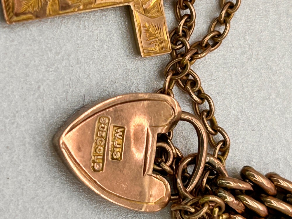 Victorian 9ct rose gold gate link bracelet featuring an engraved heart padlock clasp, safety chain, and cross charm. View V