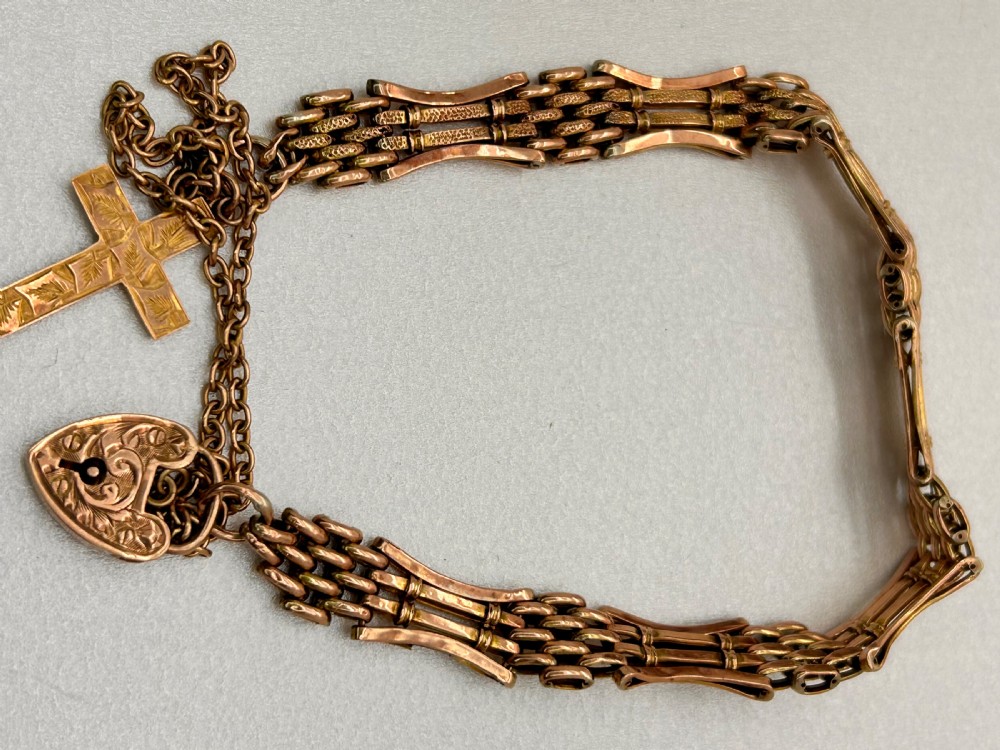 Victorian 9ct rose gold gate link bracelet featuring an engraved heart padlock clasp, safety chain, and cross charm. View VI