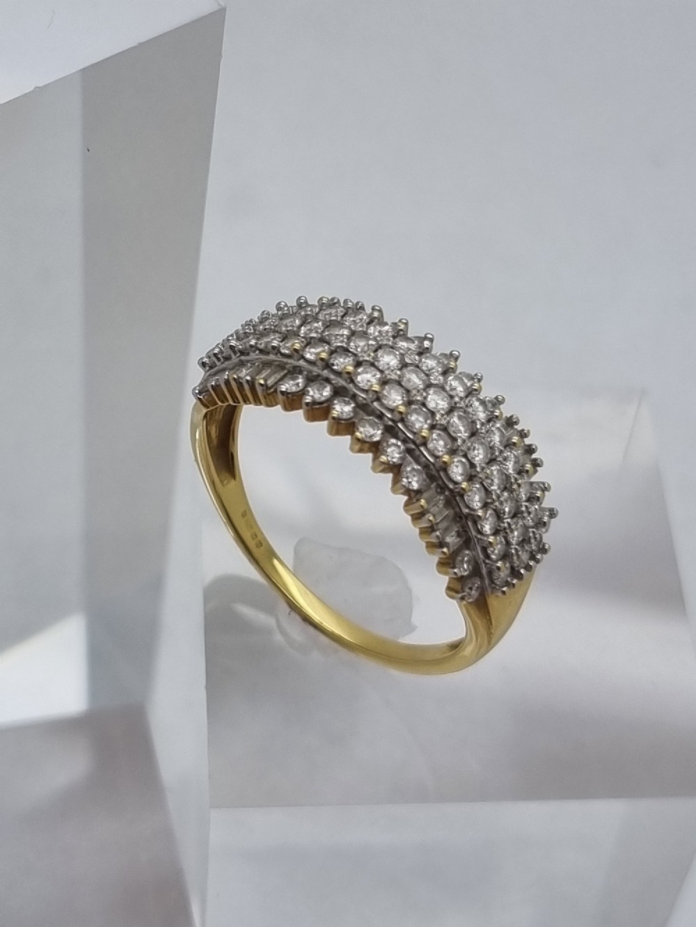 An 18ct yellow gold dress ring set with multiple rows of round brilliant diamonds across the upper band.