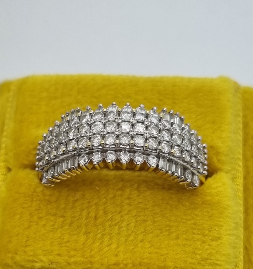 An 18ct yellow gold dress ring set with multiple rows of round brilliant diamonds across the upper band. View III