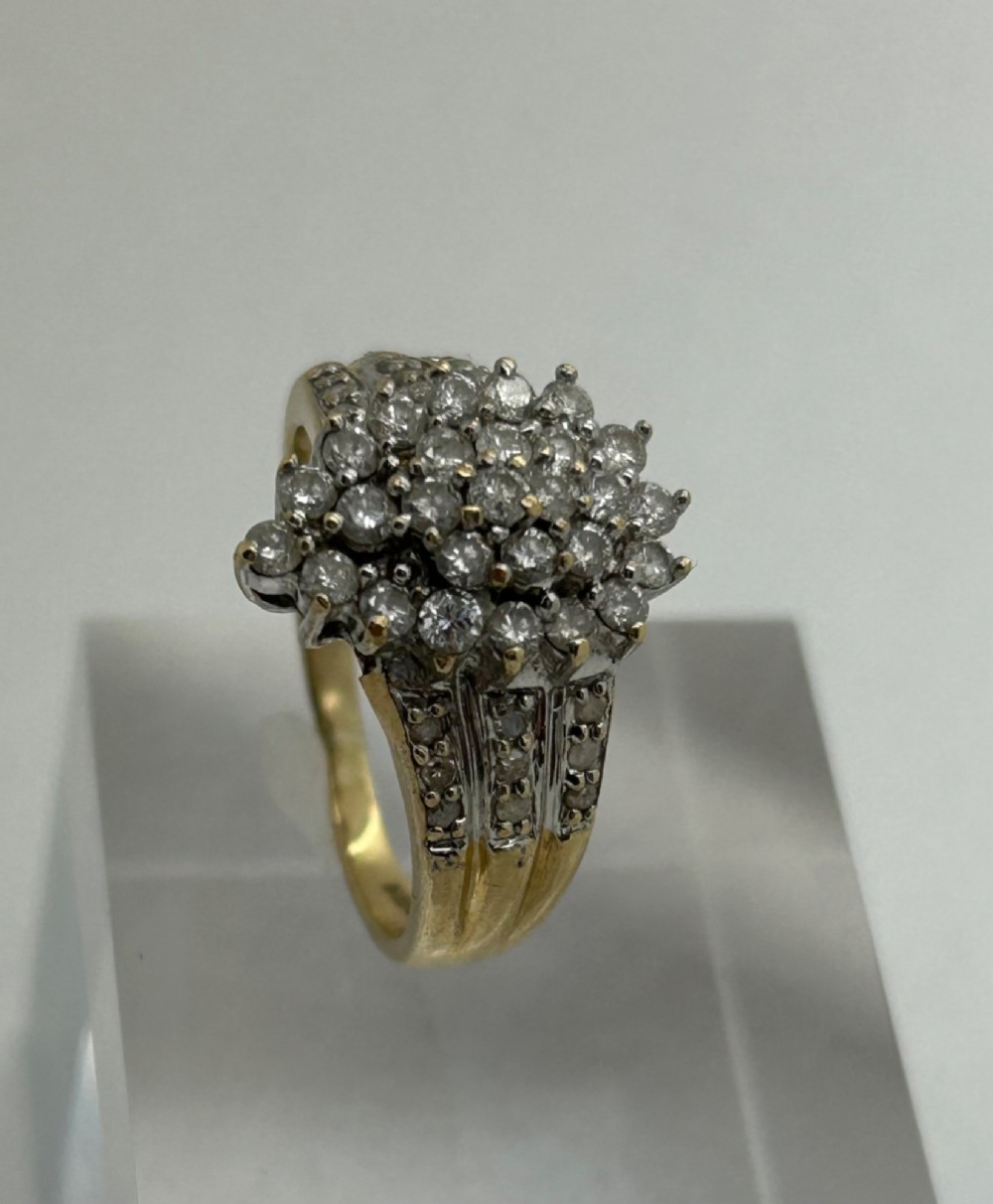 A yellow gold band ring features a central teardrop-shaped cluster of small round diamonds with additional pave diamonds set into the shoulders. View II